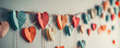 © Irina - A handmade garland of colorful paper hearts on a white wall background. Valentine's Day, birthday, wedding, anniversary, party concept banner with copy space. Children's paper crafts with parents.