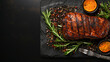 Grilled salmon fish with seasoning and various vegetables on black stone background