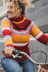 Wall Mural - Happy mature young woman riding a bike and smiling enjoying outdoor active healthy leisure activity. Green ambien and environment way of transport with female people using bicycle