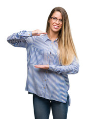 Sticker - Beautiful young woman wearing elegant shirt and glasses gesturing with hands showing big and large size sign, measure symbol. Smiling looking at the camera. Measuring concept.