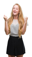 Poster - Blonde teenager woman wearing moles shirt celebrating surprised and amazed for success with arms raised and open eyes. Winner concept.