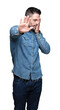 © Krakenimages.com - Young handsome man over isolated background covering eyes with hands and doing stop gesture with sad and fear expression. Embarrassed and negative concept.