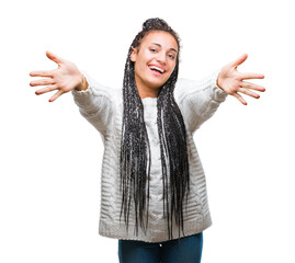 Canvas Print - Young braided hair african american girl wearing sweater over isolated background looking at the camera smiling with open arms for hug. Cheerful expression embracing happiness.