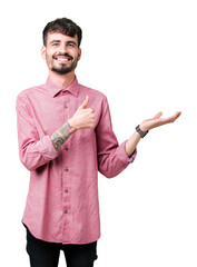 Wall Mural - Young handsome man wearing pink shirt over isolated background Showing palm hand and doing ok gesture with thumbs up, smiling happy and cheerful