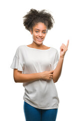 Wall Mural - Young afro american woman over isolated background with a big smile on face, pointing with hand and finger to the side looking at the camera.