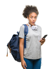 Canvas Print - Young beautiful afro american student woman holding backpack over isolated background scared in shock with a surprise face, afraid and excited with fear expression