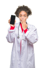 Canvas Print - Young afro american doctor woman using smartphone over isolated background cover mouth with hand shocked with shame for mistake, expression of fear, scared in silence, secret concept