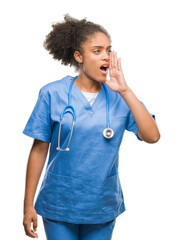 Canvas Print - Young afro american doctor woman over isolated background shouting and screaming loud to side with hand on mouth. Communication concept.