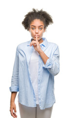 Poster - Young afro american woman over isolated background asking to be quiet with finger on lips. Silence and secret concept.