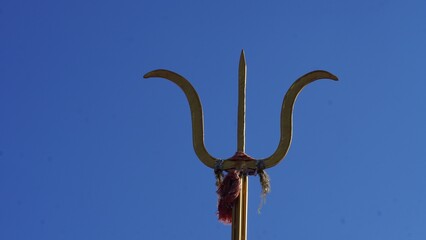 Wall Mural - closeup shot of a lord shiva trishul with sky background