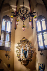 Sticker - Light, shadow and contrasts inside the Basilica of San Francesco with vintage lamps and statue of the Virgin Mary in a niche, Bologna ITALY