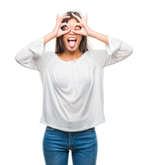 Poster - Young asian woman over isolated background doing ok gesture like binoculars sticking tongue out, eyes looking through fingers. Crazy expression.