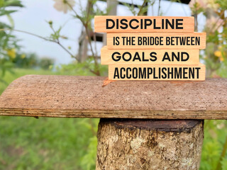 Inspirational Quote Concept - Discipline is the bridge between goals and accomplishment with blurry nature background.