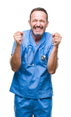 Middle age hoary senior doctor man wearing medical uniform over isolated background excited for success with arms raised celebrating victory smiling. Winner concept.