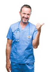 Wall Mural - Middle age hoary senior doctor man wearing medical uniform over isolated background smiling with happy face looking and pointing to the side with thumb up.