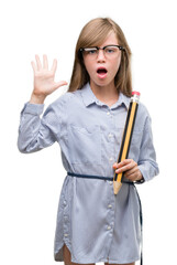 Canvas Print - Young blonde child holding big pencil very happy and excited, winner expression celebrating victory screaming with big smile and raised hands