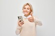 Portrait of young blond woman holding mobile phone in hand with happy smiling face. Person with smartphone isolated on white background.