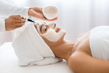 Hindu woman receiving nourishing mask at wellness spa