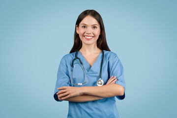 Wall Mural - Smiling nurse with arms crossed, blue background