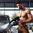 © Ольга Лукьяненко - Man washing car using washing gun on solid background. ai generative