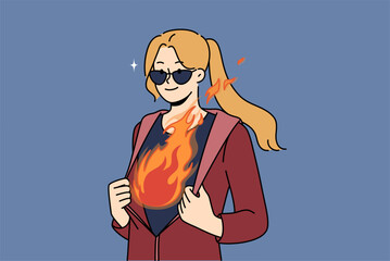 Inspired woman with flame in breast unbuttons jacket demonstrating ambition and desire to achieve goals. Cool girl in sunglasses, ready to demonstrate ambition and complete complex business tasks