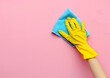 © Anastasiya - Hand in a yellow rubber glove holds a cleaning sponge and wipes a soapy foam on a background. Cleaning concept