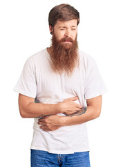 Canvas Print - Handsome young red head man with long beard wearing casual white tshirt with hand on stomach because indigestion, painful illness feeling unwell. ache concept.