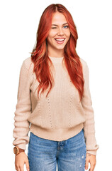 Poster - Young redhead woman wearing casual winter sweater winking looking at the camera with sexy expression, cheerful and happy face.