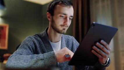 Close up view of guy using tablet. Male touching screen of device. Man spending time alone using tablet. Guy working with tablet. Guy working or studying distantly. Leisure of youth.
