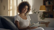 © S photographer - Caucasian woman with curly hair reading a book in her home.