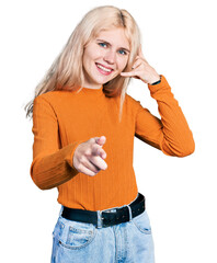 Wall Mural - Young caucasian woman wearing casual clothes smiling doing talking on the telephone gesture and pointing to you. call me.