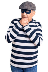 Wall Mural - Senior handsome man wearing burglar mask and t-shirt laughing nervous and excited with hands on chin looking to the side