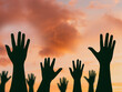 International migrants day concept: Silhouette many people raised hands over autumn sunset background