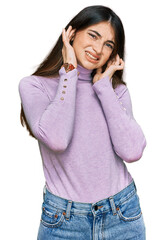 Canvas Print - Young beautiful teen girl wearing turtleneck sweater covering ears with fingers with annoyed expression for the noise of loud music. deaf concept.