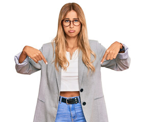 Sticker - Beautiful blonde young woman wearing business clothes pointing down looking sad and upset, indicating direction with fingers, unhappy and depressed.