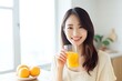 asian woman drinking orange juice