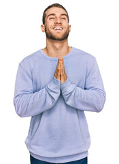 Sticker - Young caucasian man wearing casual clothes begging and praying with hands together with hope expression on face very emotional and worried. begging.