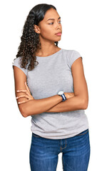 Wall Mural - Young african american girl wearing casual clothes looking to the side with arms crossed convinced and confident