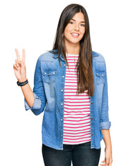 Poster - Young brunette woman wearing casual clothes smiling looking to the camera showing fingers doing victory sign. number two.