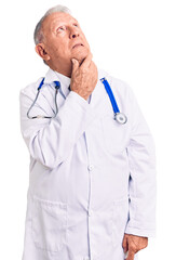 Canvas Print - Senior handsome grey-haired man wearing doctor coat and stethoscope thinking worried about a question, concerned and nervous with hand on chin