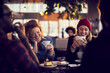 © Marko Geber - Smiling young diverse people sitting in cafe