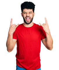 Sticker - Young arab man with beard wearing casual red t shirt shouting with crazy expression doing rock symbol with hands up. music star. heavy concept.