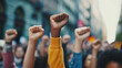 © GeorgeAI - Multi-ethnic people with raised fists. Huge crowd in the middle of the street
