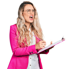 Poster - Young blonde woman writing on clipboard angry and mad screaming frustrated and furious, shouting with anger. rage and aggressive concept.