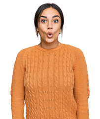 Wall Mural - Young brunette woman wearing casual winter sweater afraid and shocked with surprise expression, fear and excited face.