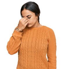 Young brunette woman wearing casual winter sweater tired rubbing nose and eyes feeling fatigue and headache. stress and frustration concept.