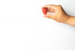  man's hand holding fresh organic strawberries on a neutral white background
