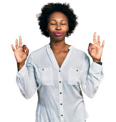 Poster - African american woman with afro hair wearing casual white t shirt relax and smiling with eyes closed doing meditation gesture with fingers. yoga concept.