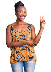 Sticker - Young african american woman wearing casual clothes smiling looking to the camera showing fingers doing victory sign. number two.