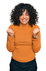 Poster - Young hispanic woman wearing casual clothes excited for success with arms raised and eyes closed celebrating victory smiling. winner concept.